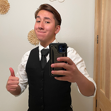 Oscar Aguilar taking a mirror selfie of himself in a vest.