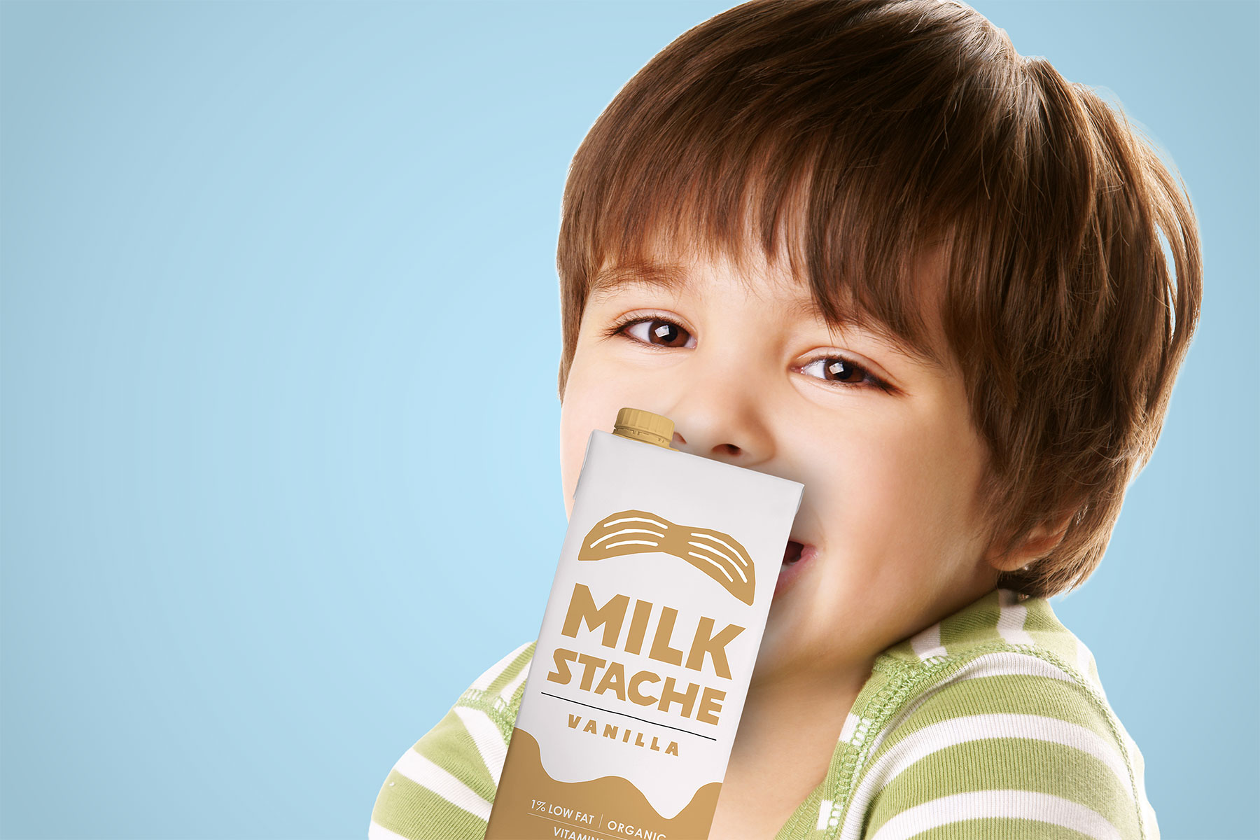 Child holding vanilla MilkStache kid carton